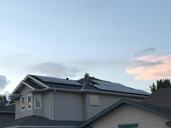 House roof with installed solar panels at sunset