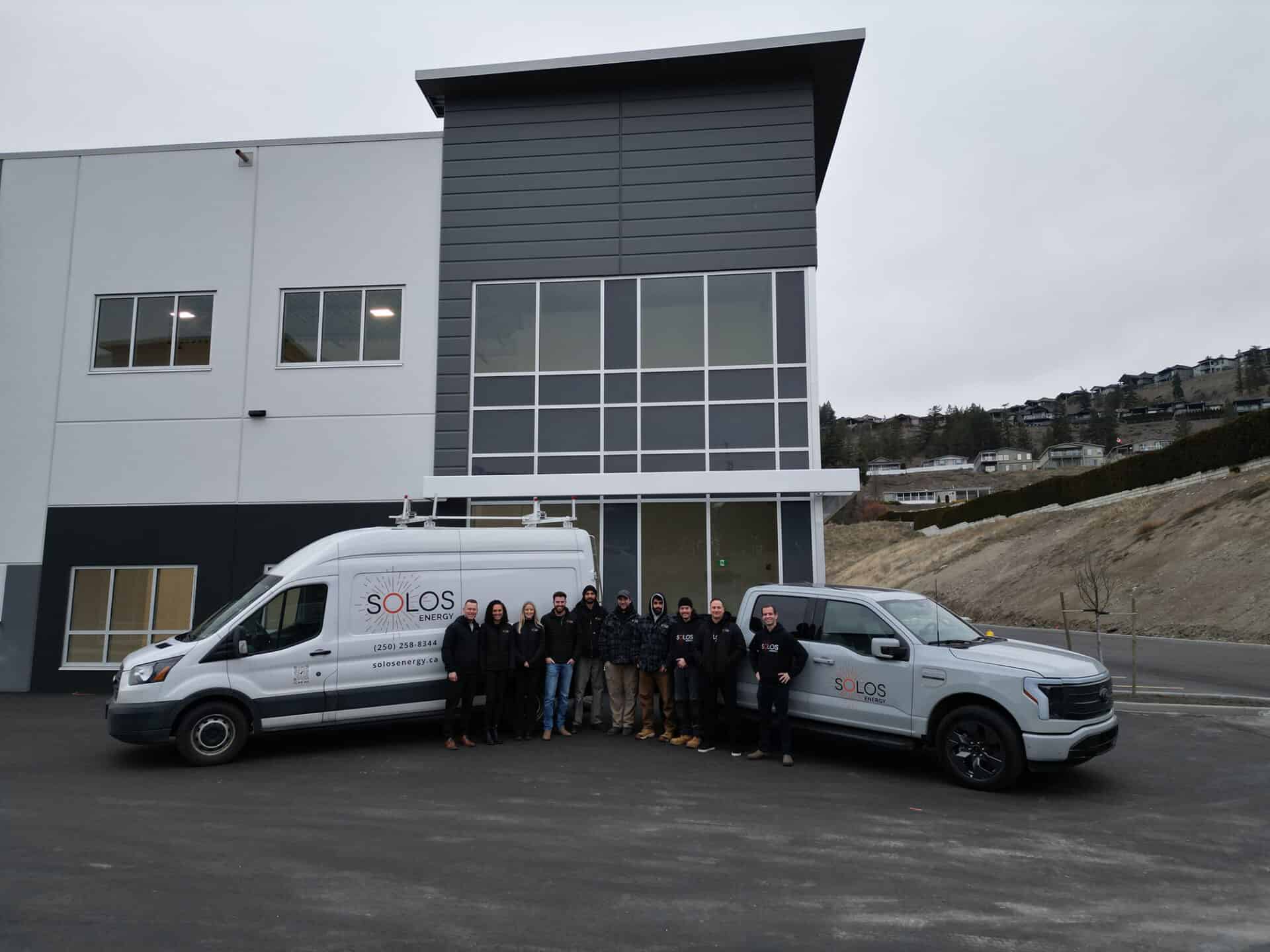 Solos Energy team outside office with company vehicles